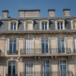 Façade en pierre d’un immeuble ancien avec balcons en fer forgé